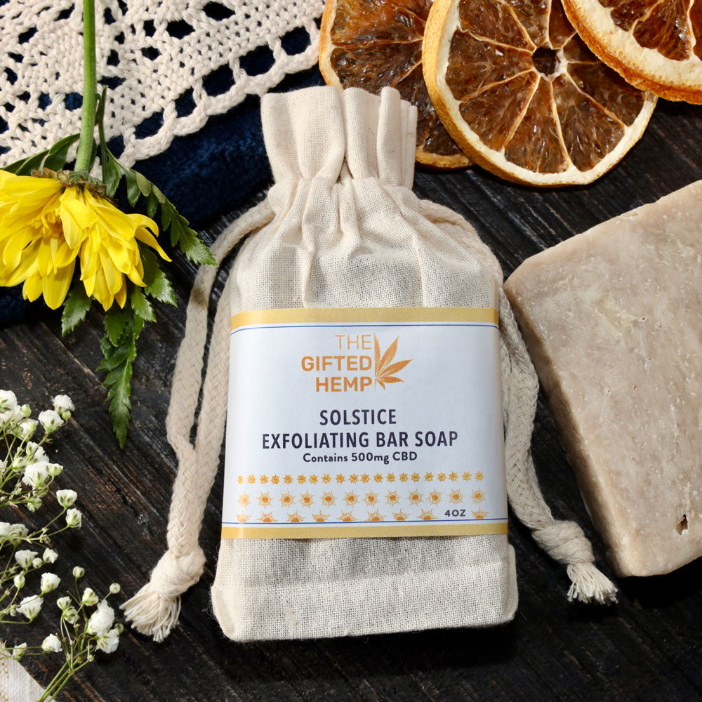 Bar of Exfoliating Soap -Solstice wrapped in a canvas bag with citrus and flowers.