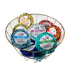 A wire basket filled with multiple wrapped shower steamers in various colors from The Gifted Hemp