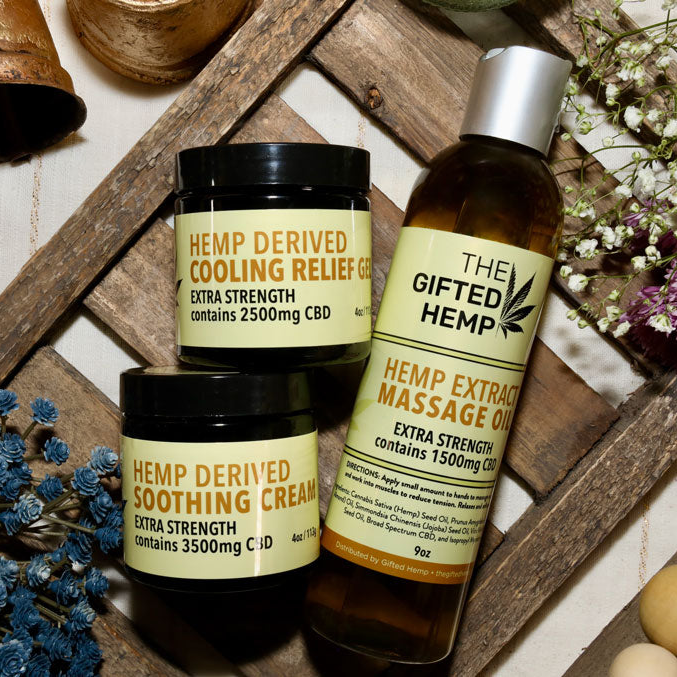 Image of The Gifted Hemp Cooling Gel, Soothing Cream, and Massage Oil, on a wooden background